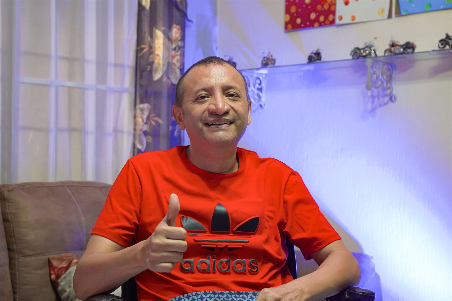 Mario Ortiz sonriendo y saludando desde su hogar